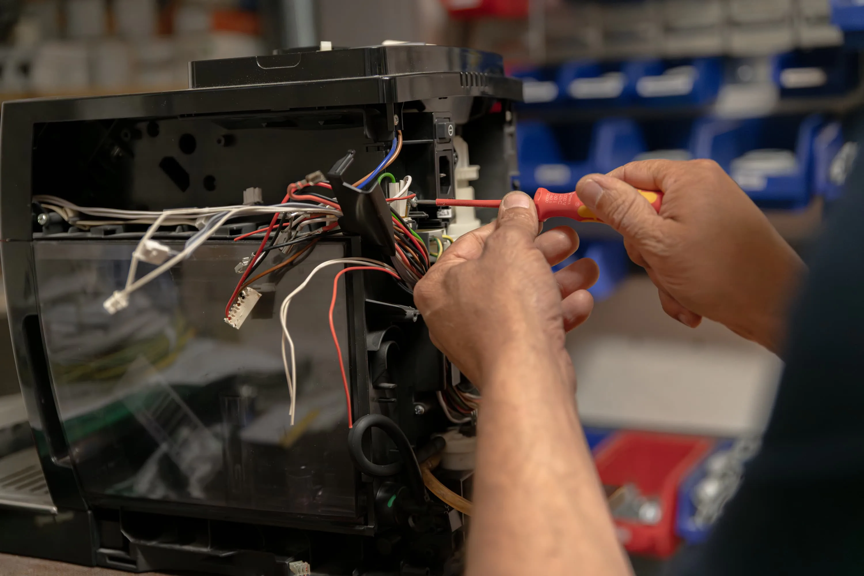 Elektriker mit rotem Handschuh vor einer Schalttafel